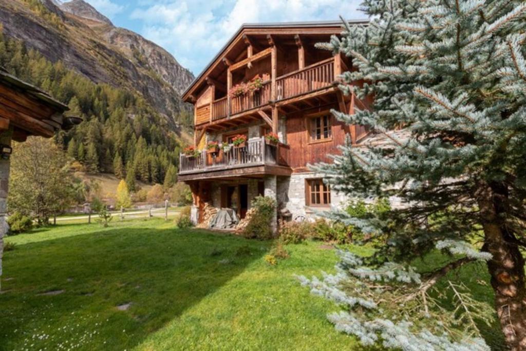 a large wooden building with a balcony in a field at CASA-Chalet Brizolée lake-view chalet in Tignes close to ski area in Tignes