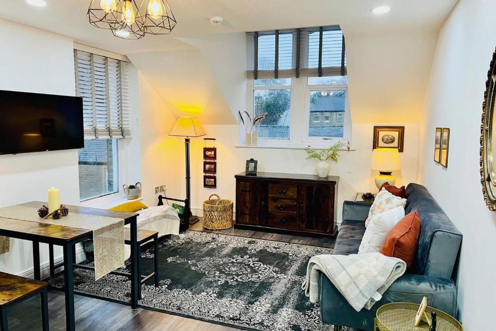 a living room with a couch and a table at Top floor apartment in central Buxton in Buxton