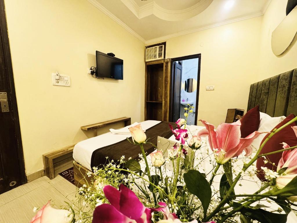 新德里的住宿－Staybook Hotel Jai Balaji, Paharganj, New Delhi Railway Station，配有床和鲜花的酒店客房