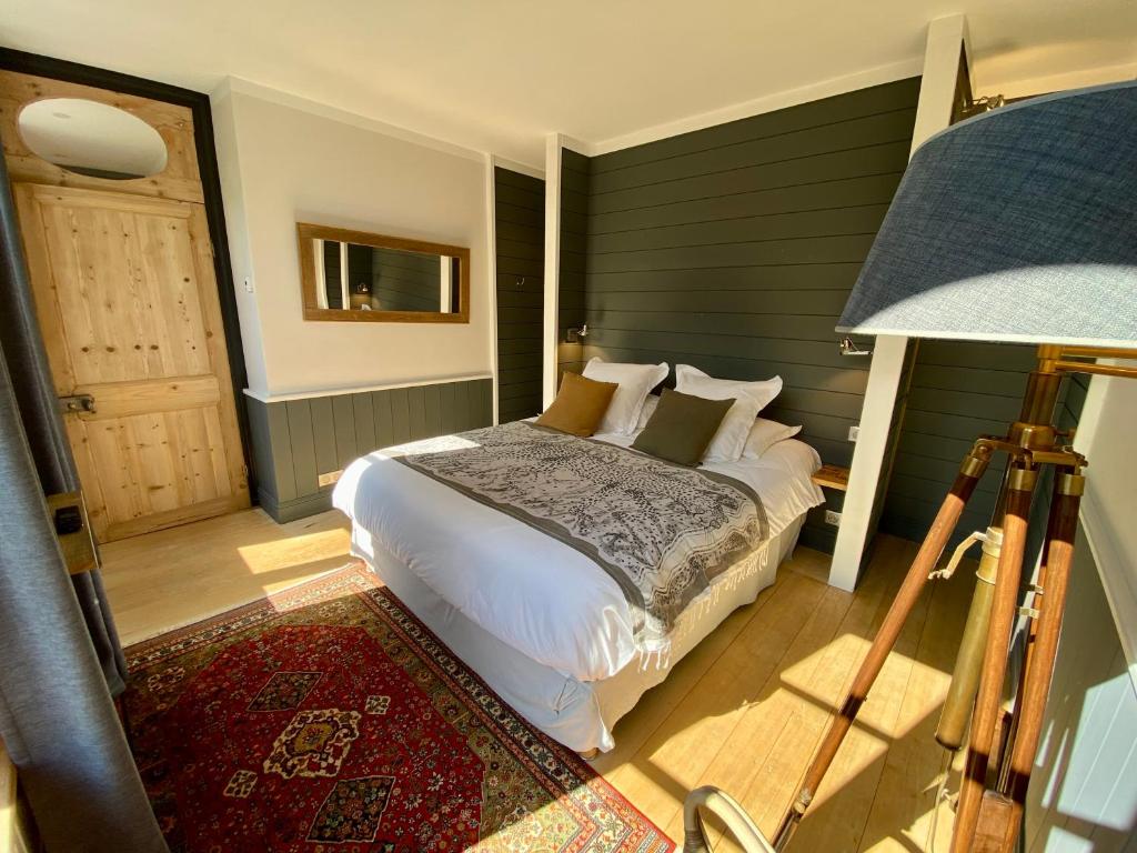 um quarto com uma cama grande e um candeeiro em Côté Baie em Saint-Valery-sur-Somme