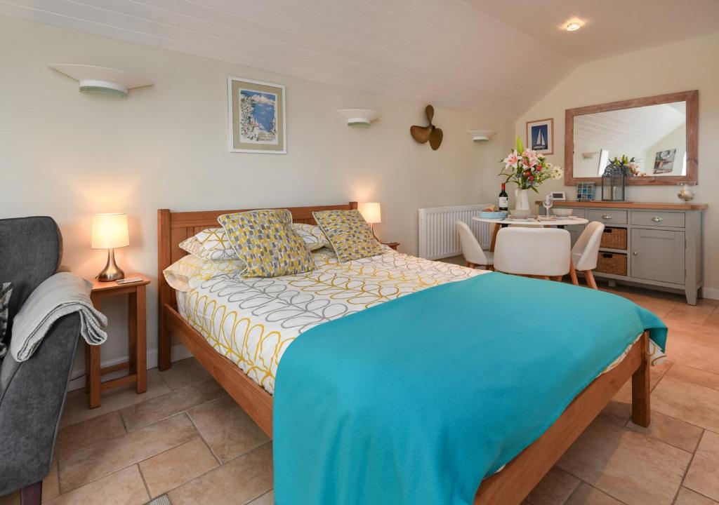 a bedroom with a bed and a desk and a chair at Y Ddol Bach in Abersoch