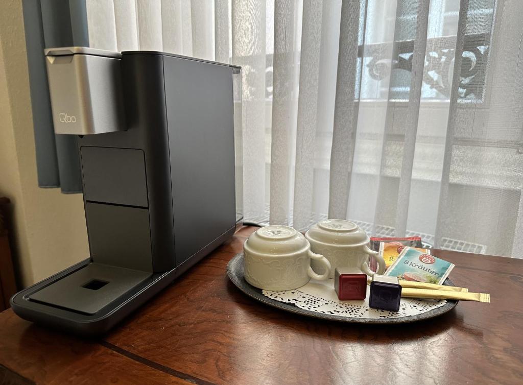 a computer monitor and two cups on a plate on a table at Hotel Rathausglöckel in Baden-Baden