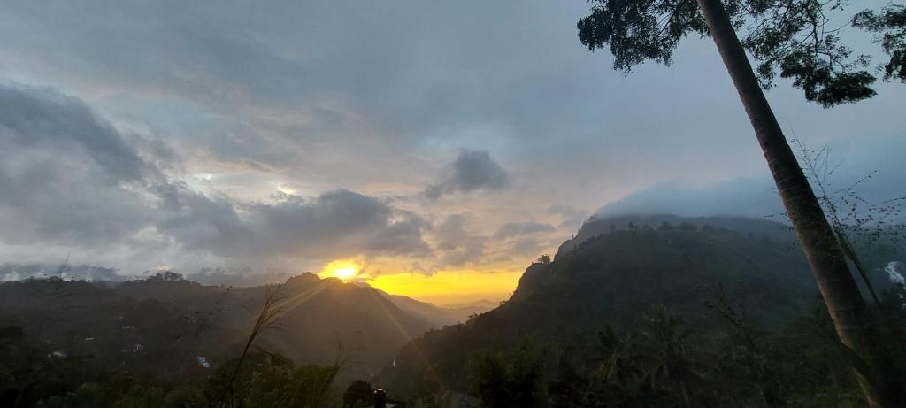 una vista de la puesta de sol en una montaña en meditation monastery stay en Ella