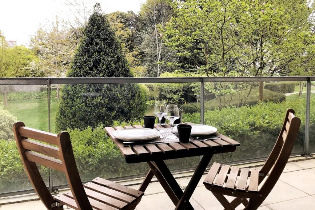 d'un balcon avec une table en bois et deux chaises. dans l'établissement L'Amazone-Appart au calme avec balcon et parking, à Nantes