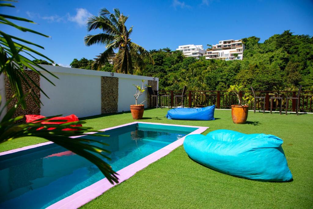 un patio trasero con piscina y césped verde en Chillax Boracay en Boracay