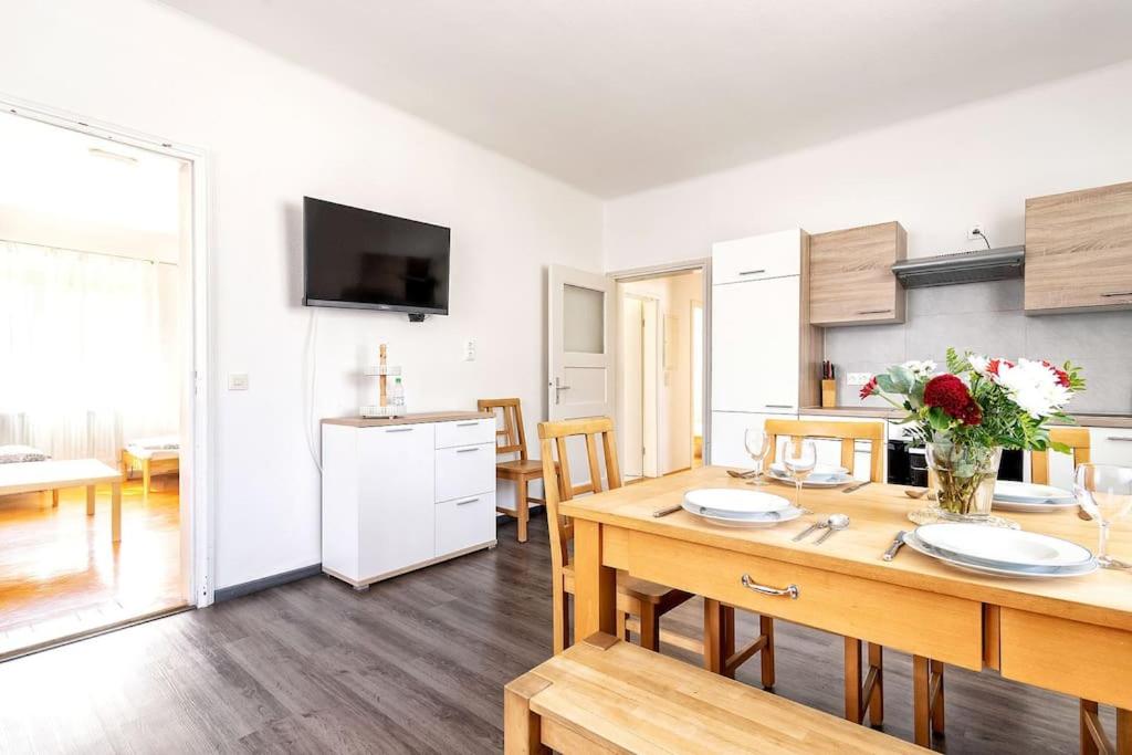 Una cocina y una sala con una mesa y un comedor. en Alpen-Hostel Apartment Mittelstation Süd mit Motorradvermietung, en Memmingen