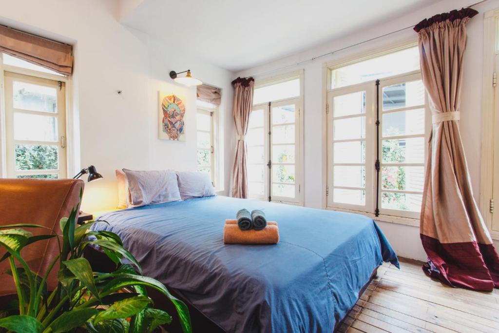 ein Schlafzimmer mit einem blauen Bett mit zwei schwarzen Objekten darauf in der Unterkunft Bunker - The Suite in Ho-Chi-Minh-Stadt
