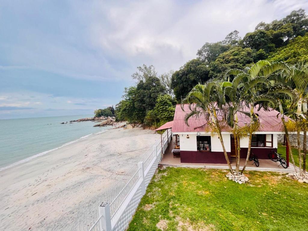a house on the beach next to the ocean at Seaview Mini Chalet - Direct Beach Access in Tanjung Bungah