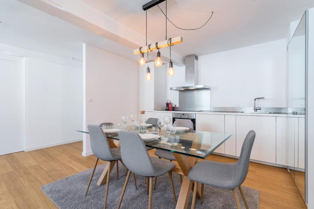 une salle à manger avec une table et des chaises en verre dans l'établissement Apartment in the heart of Old Lille, à Lille