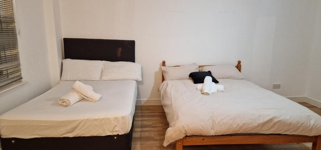 two beds sitting next to each other in a room at Urban Retreat Studio Apartment in London in London