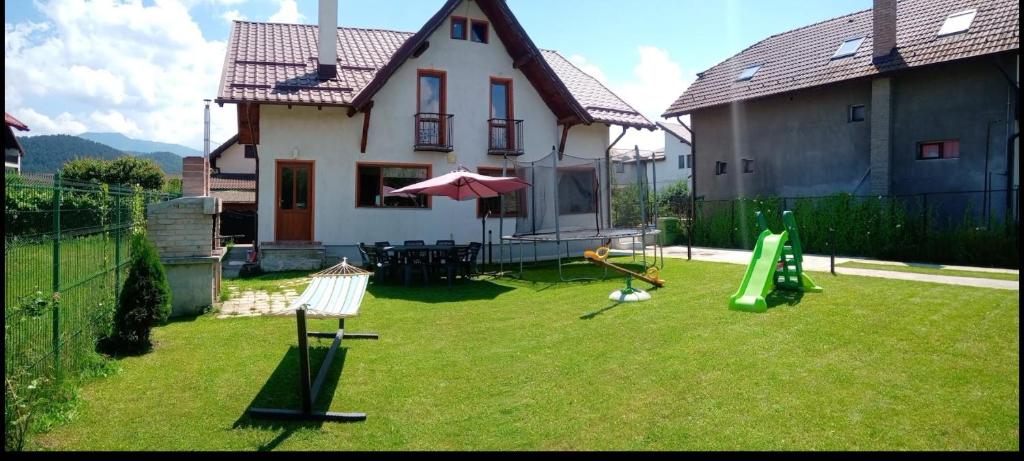 un patio con parque infantil y una casa en Vila Decebal, en Râșnov
