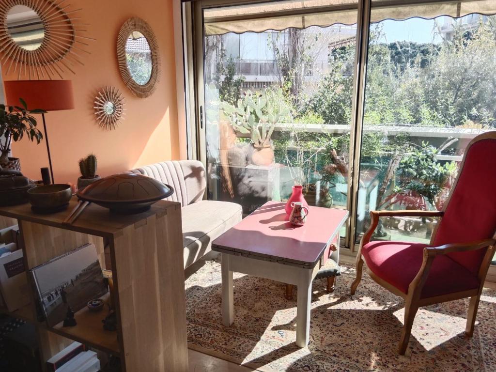 un salon avec une table rose et une fenêtre dans l'établissement STUDIO VILLA VIANNEY, à Cannes