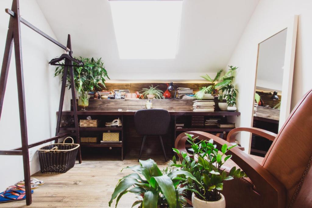胡志明市的住宿－Bunker - The Writer's Loft，配有带植物的书桌和椅子的客房