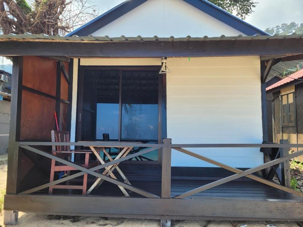 a house with a porch with a wooden fence at The Station Tioman in Tioman Island