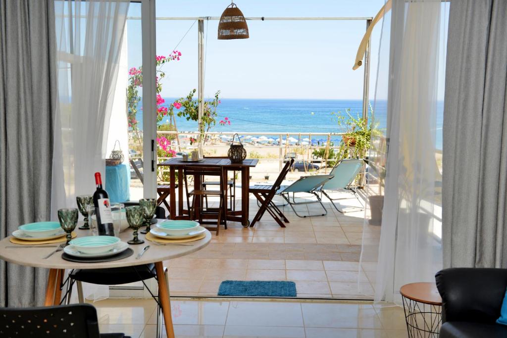 a living room with a table and a view of the beach at Studio Mare Faliraki in Faliraki
