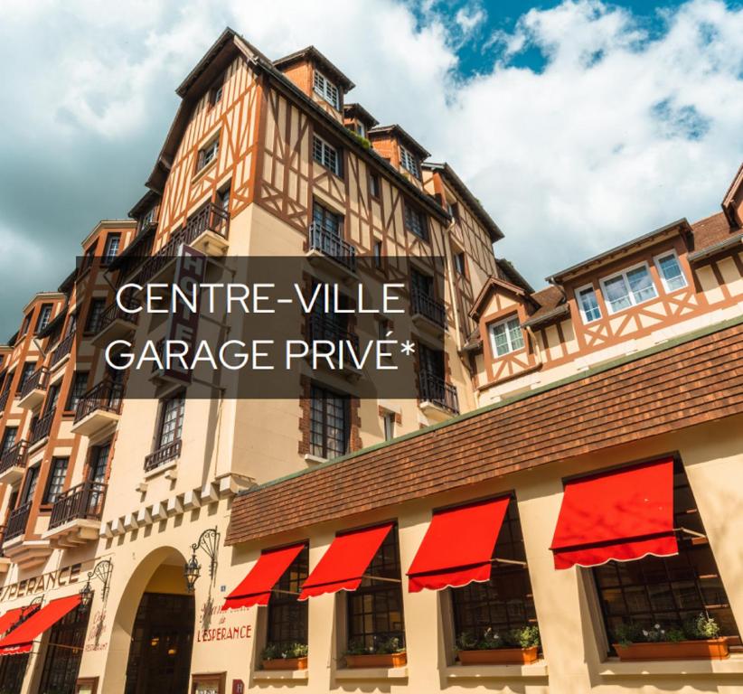 um edifício com uma placa que lê Central Village GaragePrince em L'Hotel De L'Esperance em Lisieux