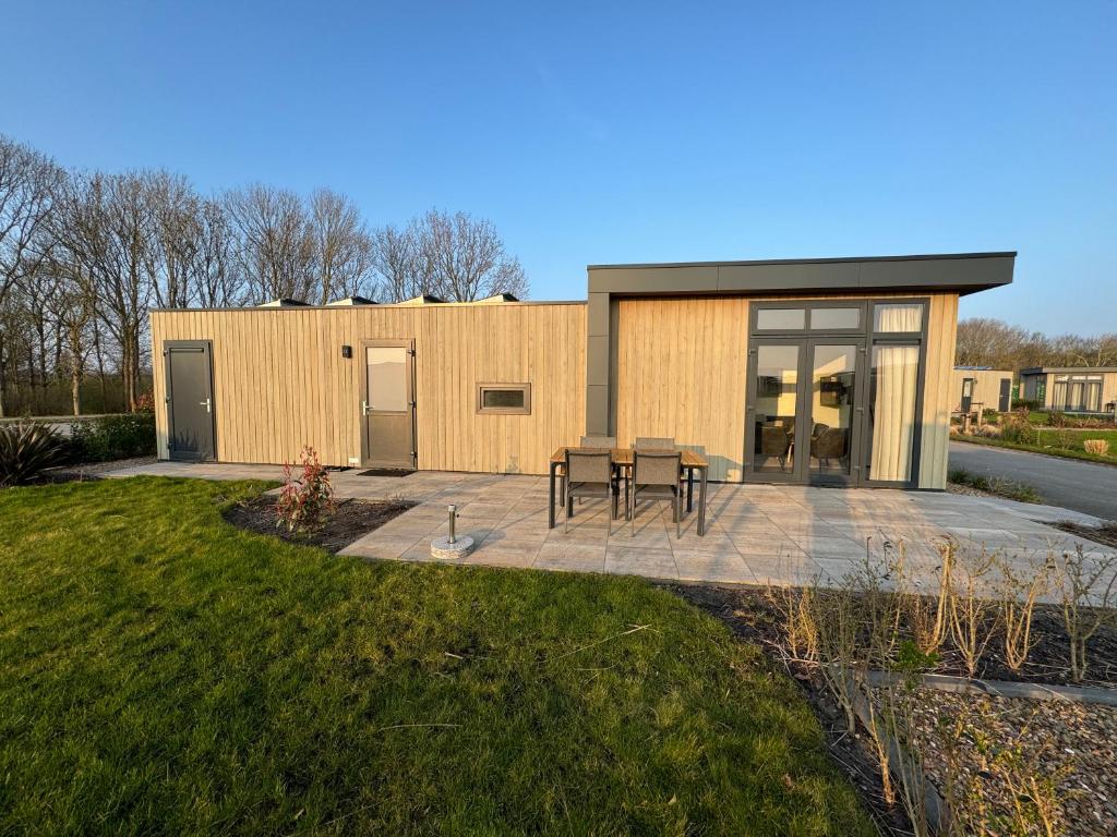 a house with two tables in front of it at Enkhuizer Strand Chalet AusZeit Haus Nr 243 in Enkhuizen