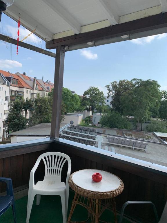 un piccolo tavolo con sedie su un balcone con vista di Pension Obenaus a Lipsia