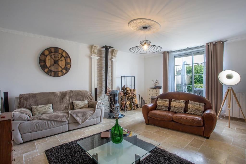 a living room with a couch and a chair at L'escapade Vendéenne - Grand jardin 4 chambres in Vix