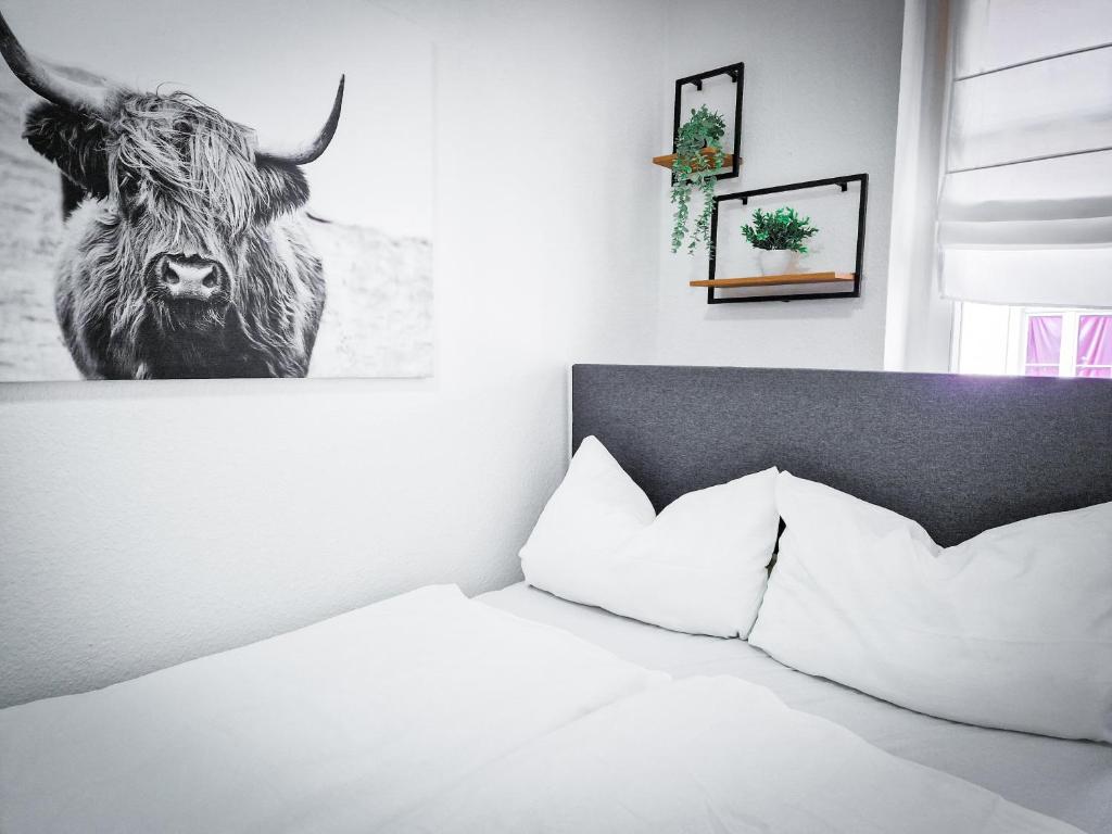 uma cama com uma foto de uma vaca na parede em großzügige Altstadtwohnung Lara für 6 Personen em Weißenfels