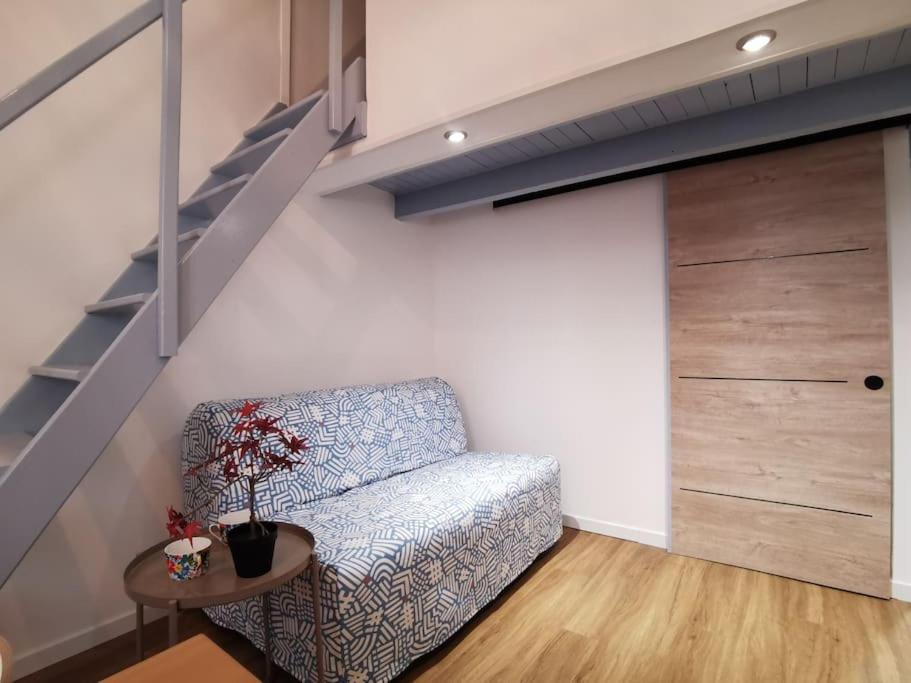 ein Wohnzimmer mit einem Sofa und einer Treppe in der Unterkunft Massalia Apartement, Le Panier in Marseille