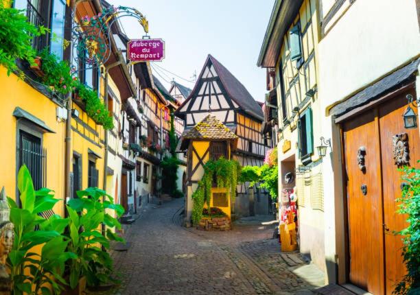 Une ruelle dans une vieille ville avec des bâtiments dans l'établissement Chambre Super Broussard, à Eguisheim