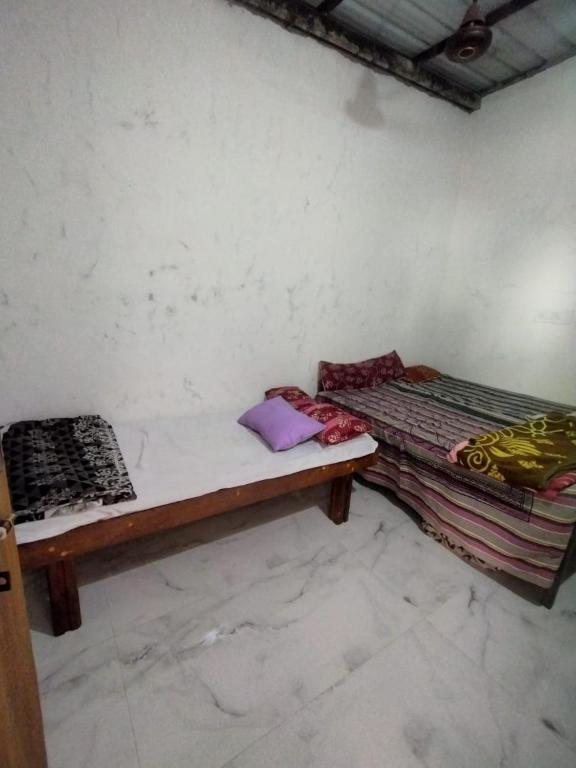 a room with two beds sitting next to a wall at Karthik home stay in Hampi