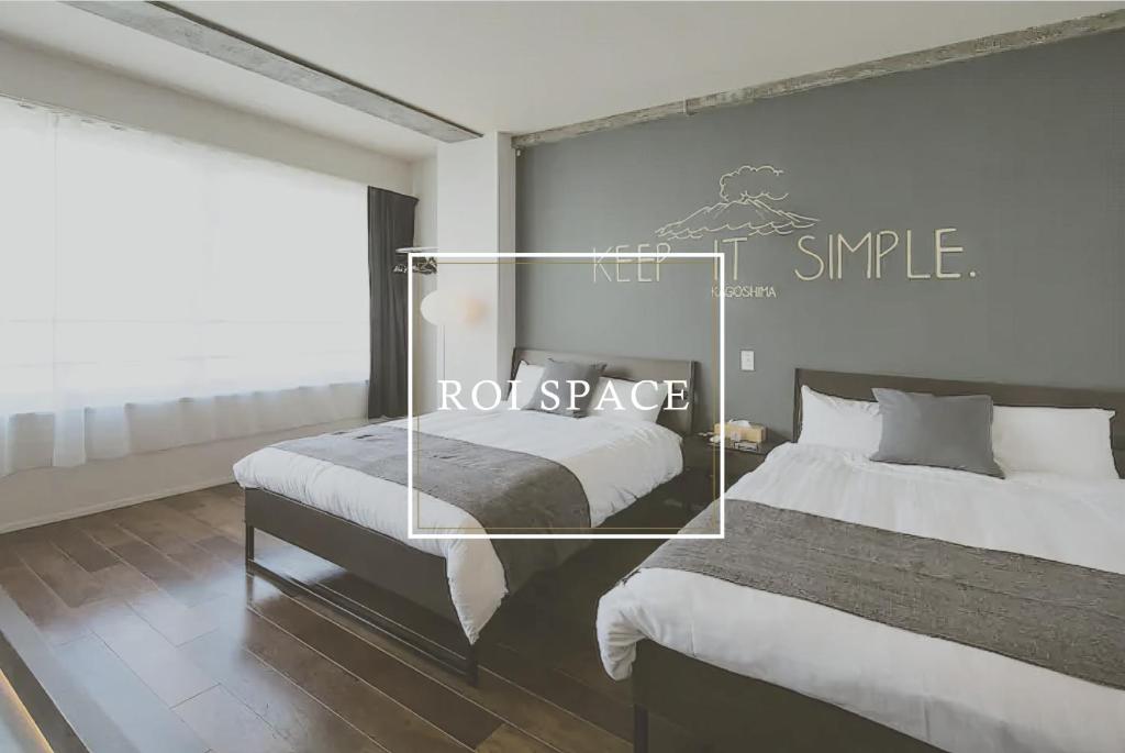 een kamer met twee bedden en een bord met roderuimte bij ROI SPACE 鹿児島 in Kagoshima