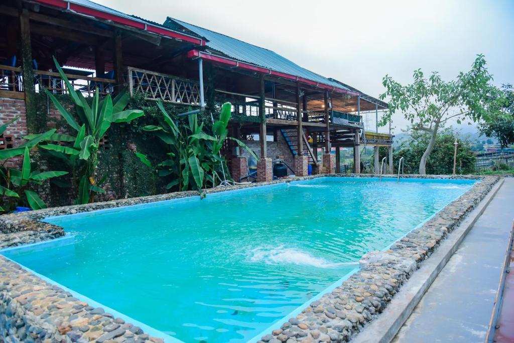 une grande piscine bleue en face d'un bâtiment dans l'établissement Stella Mộc Châu Homestay, à Mộc Châu