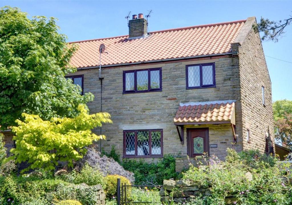 an old stone house with a red roof at Moraine in Ravenscar