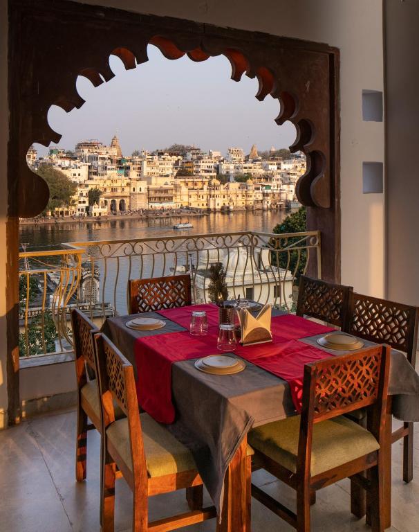 a dining room table with a view of the city at DERA PICHOLA- A Lake Facing Boutique Hotel in Udaipur