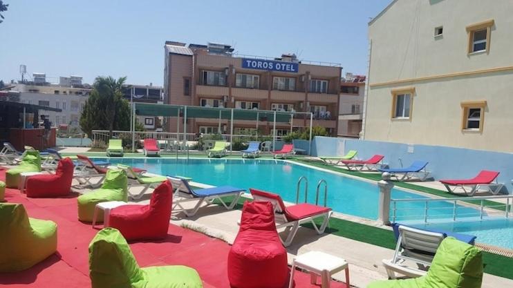 a swimming pool with chairs and a hotel at TOROS OTEL DİDİM in Didim