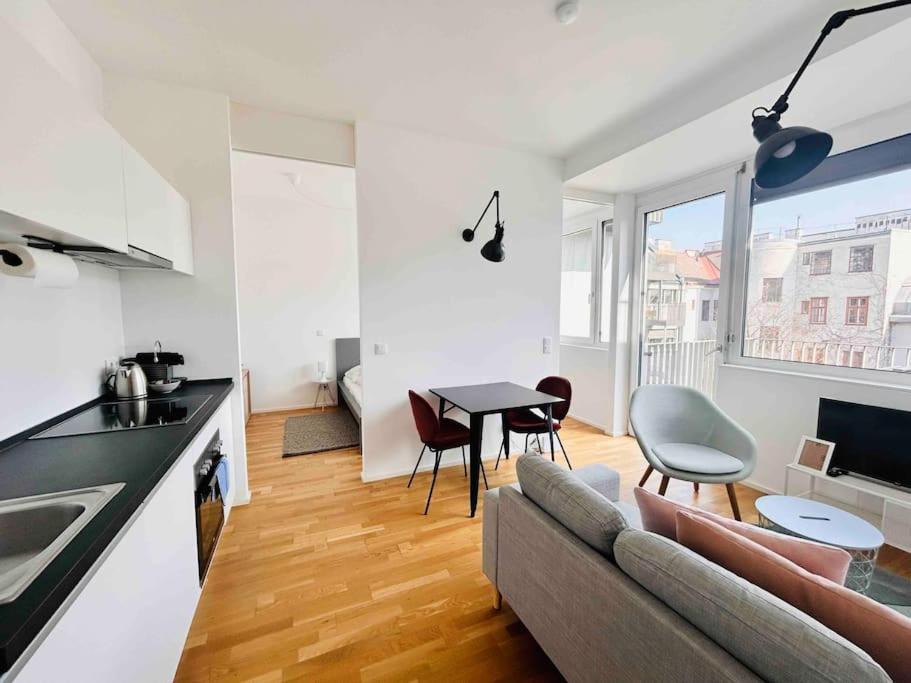 een keuken en een woonkamer met een bank en een tafel bij Designer flat to feel good in in Wenen