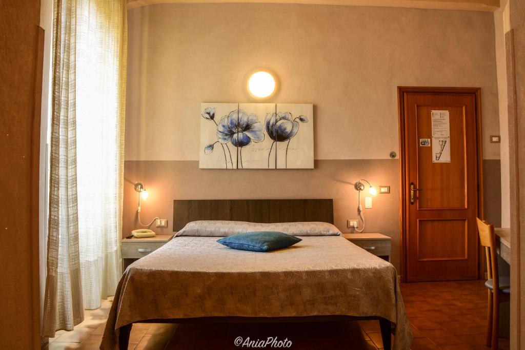 a bedroom with a bed with a blue pillow on it at Albergo Florida Taggia in Taggia