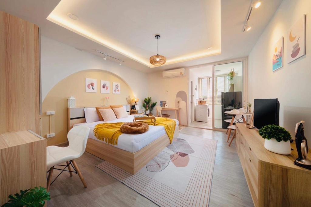 - une chambre avec un grand lit et une télévision dans l'établissement Srithana Condominium Cozy Room, à Chiang Mai
