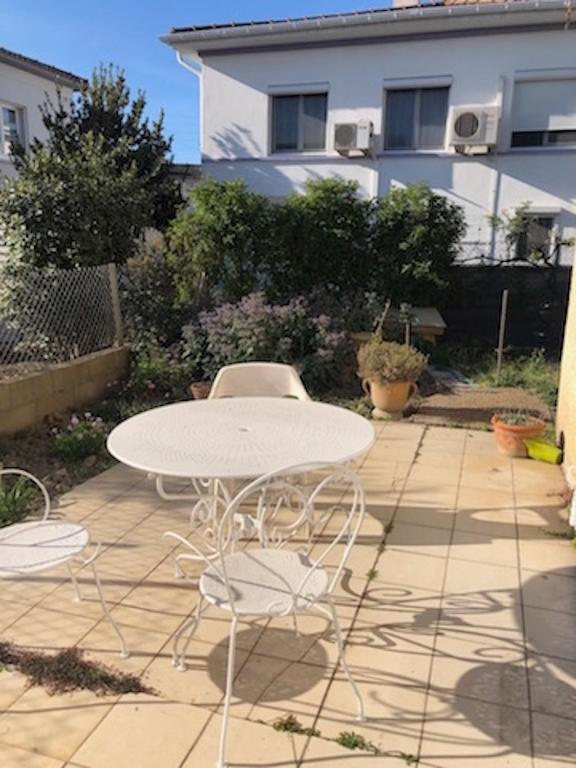 une table blanche et des chaises sur une terrasse dans l'établissement 2 pièces Arles, à Arles