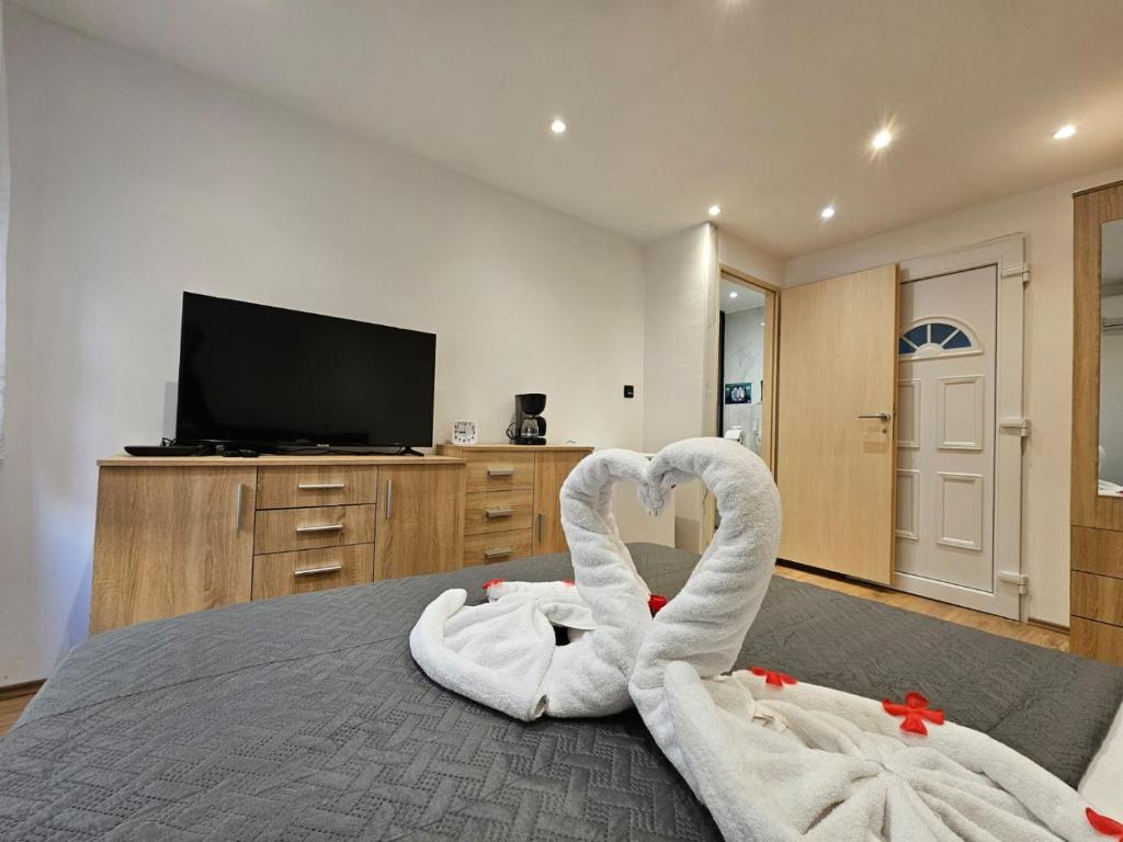two swans are sitting on a bed in a bedroom at Centar RI-ROOM in Rijeka