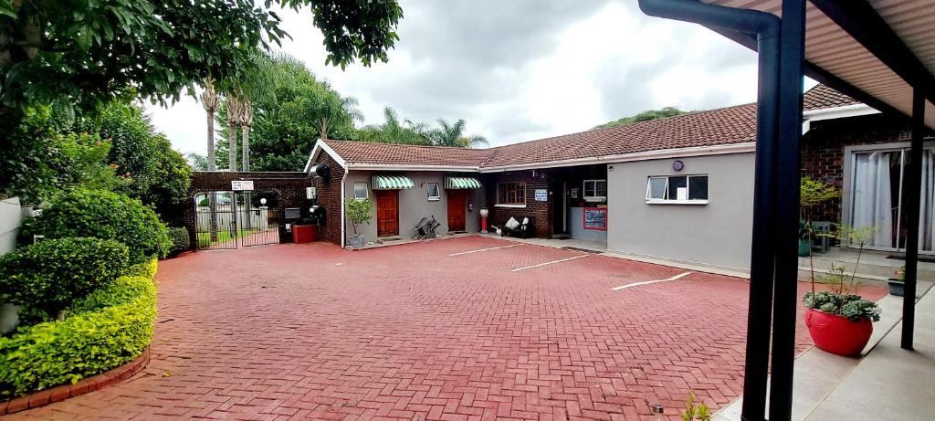 a brick parking lot in front of a building at UNIQUE BnB in Vryheid