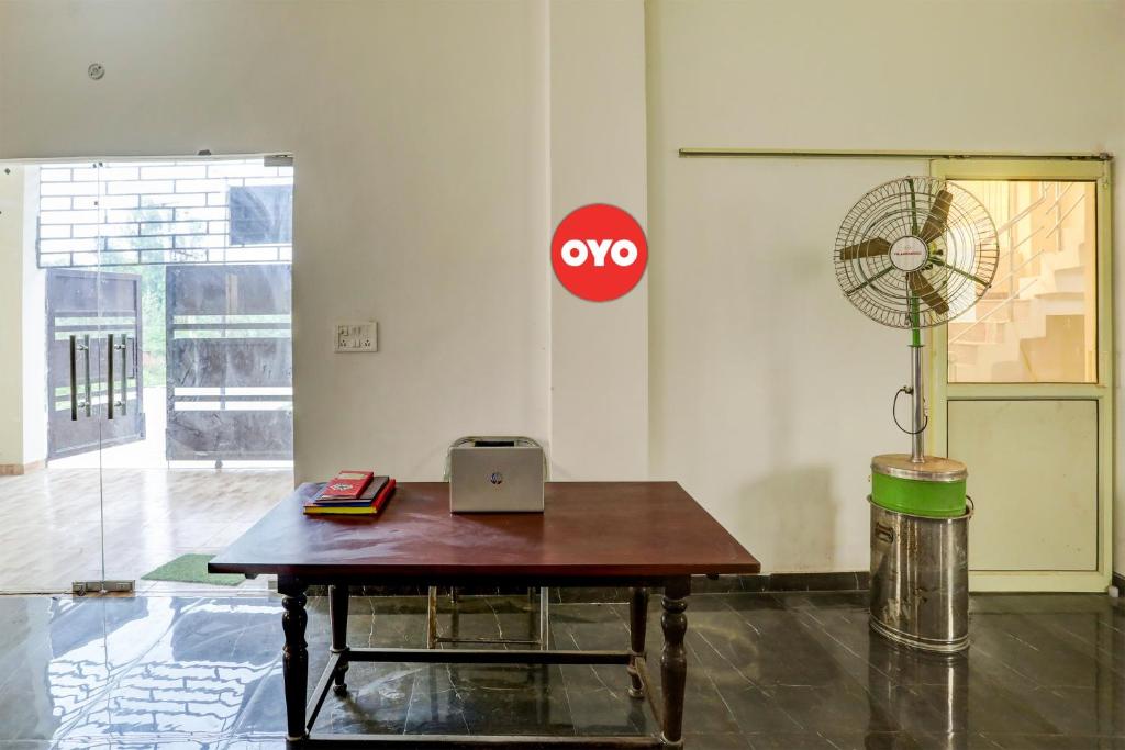 a table with a laptop and a fan in a room at Super OYO Flagship Sunrise Inn in Lucknow