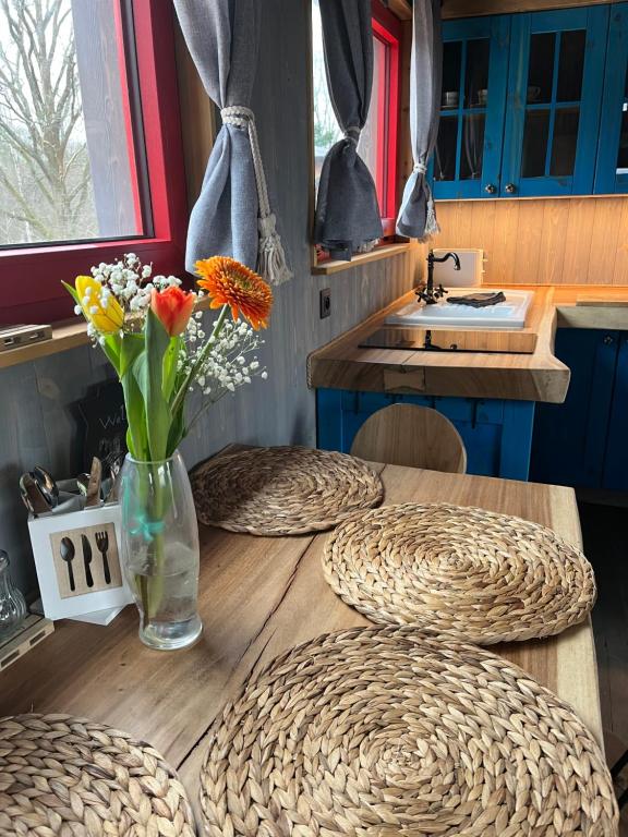 a table with chairs and a vase of flowers on it at Pension U Stříbrného Jelena - Tiny House in Cheb