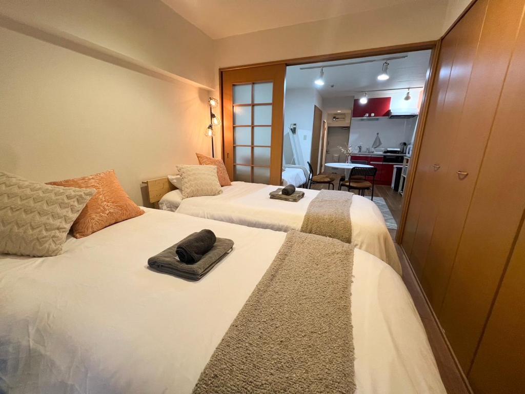 ein Hotelzimmer mit 2 Betten und Handtüchern darauf in der Unterkunft 渋谷Eアドレス in Tokio