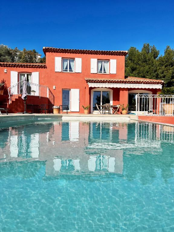 une grande piscine devant une maison dans l'établissement Villa avec piscine, Vue mer, climatisée Proche Bandol, à Saint-Cyr-sur-Mer