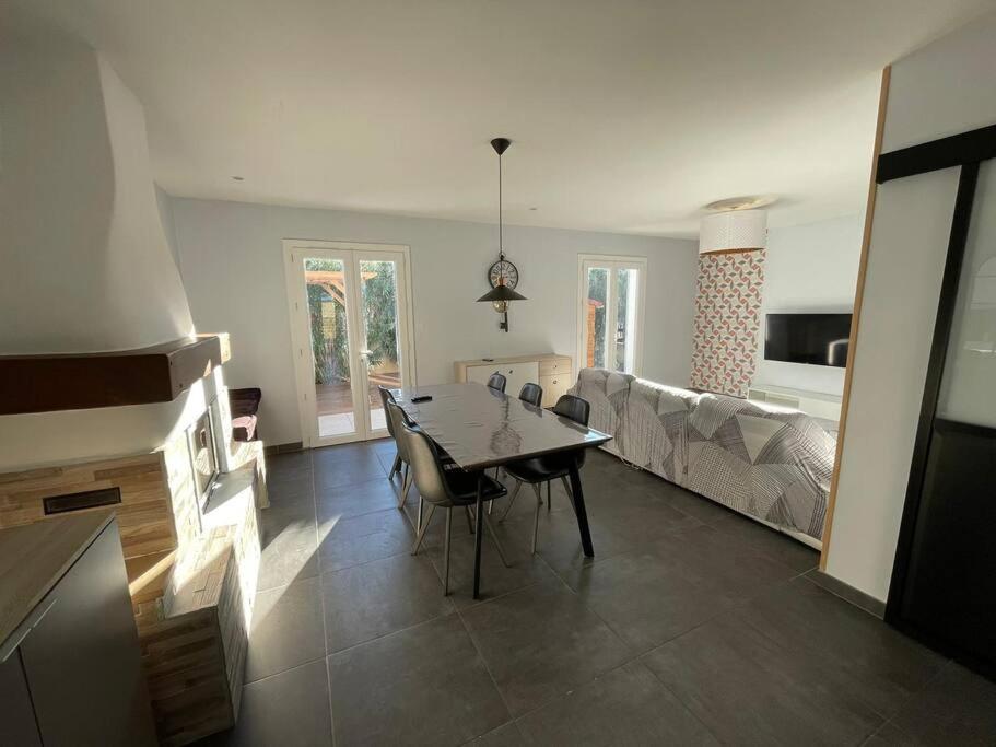 a living room with a table and a couch at Maison cosy avec piscine au port - proche Narbonne in Bages
