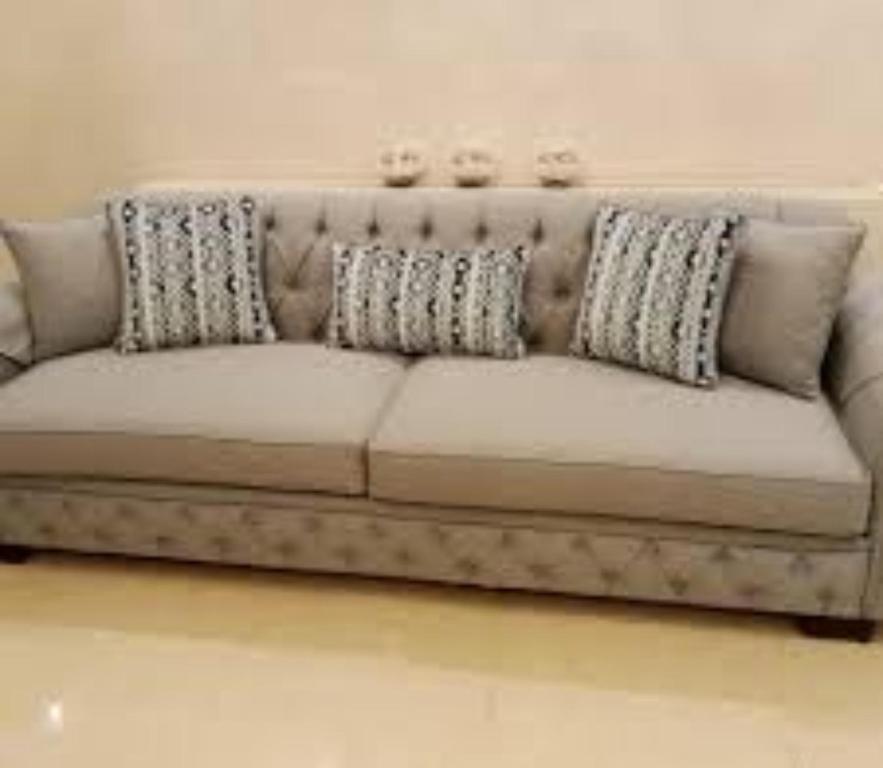 a couch in a living room with pillows on it at كيان شقق مفروشة in Hafr Al Baten