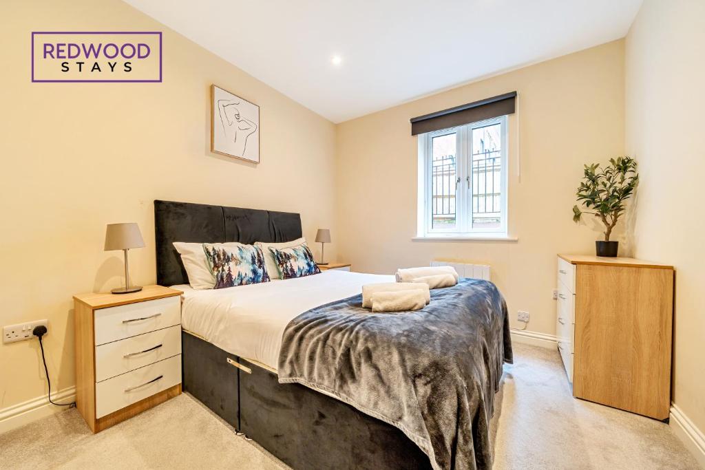 a bedroom with a large bed and a window at Festival Place, Town Center Serviced Apartments, Perfect of Contractors & Families FREE Wifi & Netflix By REDWOOD STAYS in Basingstoke