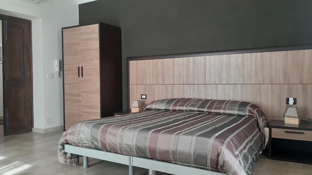 1 dormitorio con cama grande y cabecero grande en Casa Antioco B&B, en Siracusa