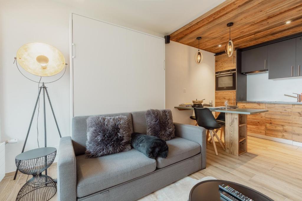 sala de estar con sofá y cocina en Studio rénové et élégant en plein centre en Crans-Montana