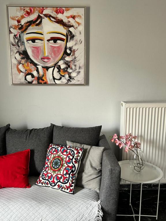 a living room with a couch and a painting on the wall at Beautiful apartment next to metro station in Athens