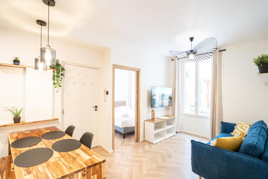 un salon avec un canapé bleu et une table dans l'établissement Meynadier Premium 2BR Refurb 2023 Olam Properties, à Cannes