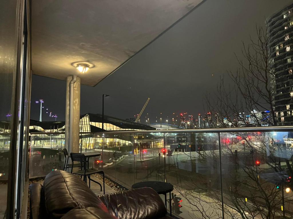a balcony with a view of a city at night at Luxury Dockview 3 Beds Excel London in London